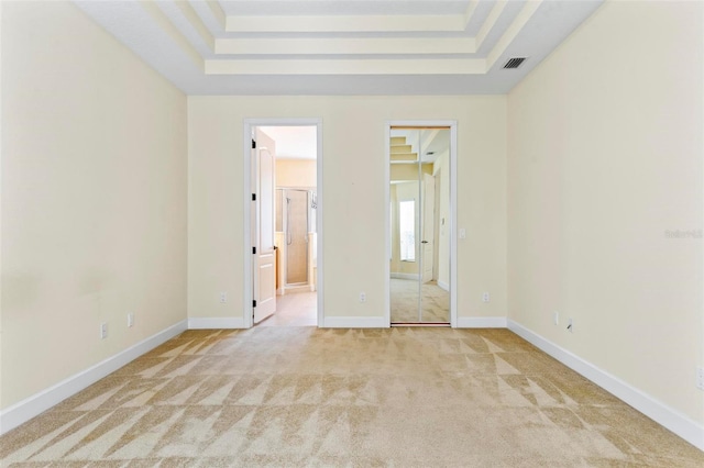 carpeted spare room with a tray ceiling