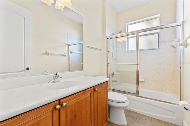 full bathroom featuring tile patterned floors, vanity, toilet, and enclosed tub / shower combo