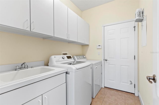 laundry area with cabinets, washing machine and dryer, sink, and light tile patterned flooring