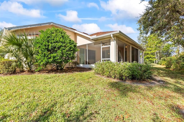 rear view of property featuring a sunroom and a yard