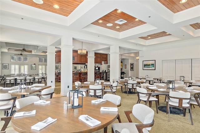 carpeted dining area featuring ornate columns, ceiling fan, wood ceiling, and coffered ceiling