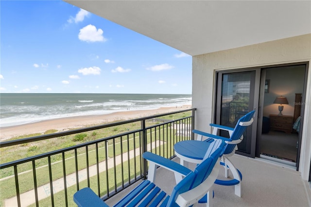 balcony with a water view and a beach view