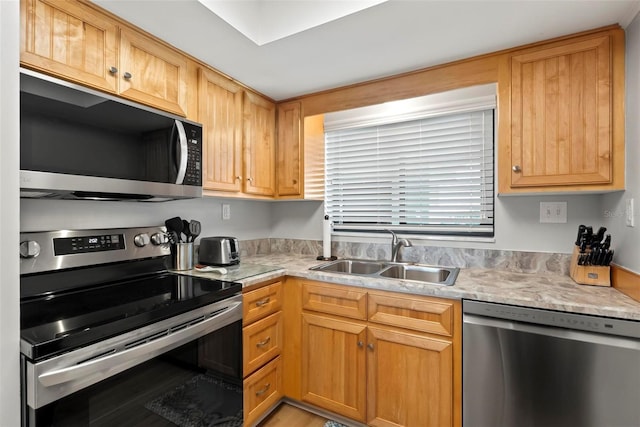 kitchen with stainless steel appliances, light hardwood / wood-style flooring, and sink