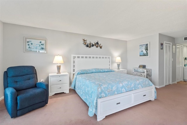 carpeted bedroom featuring multiple closets