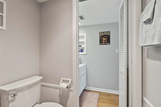 bathroom with hardwood / wood-style flooring, vanity, and toilet