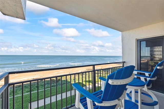 balcony featuring a beach view and a water view