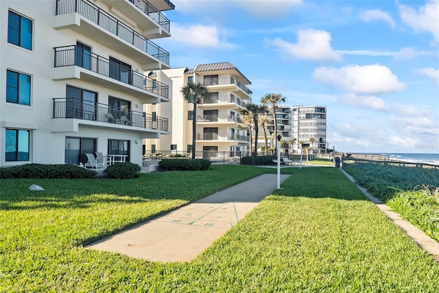 view of home's community with a lawn and a water view