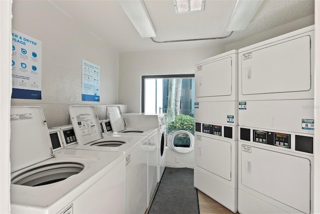 laundry area featuring washing machine and dryer, stacked washer / dryer, and dark wood-type flooring