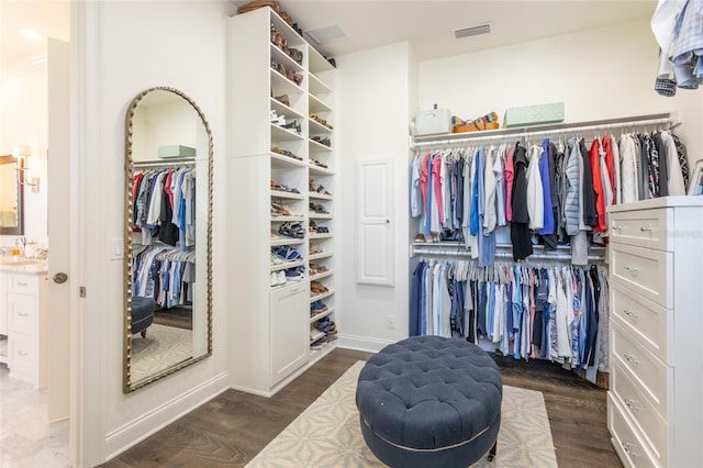 walk in closet with dark wood-type flooring