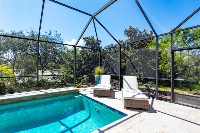 view of swimming pool featuring a patio and a lanai