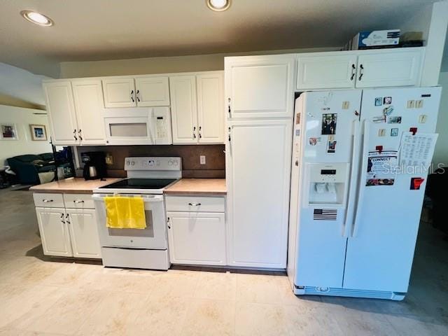 kitchen featuring white cabinetry and white appliances