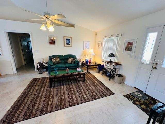 living room with ceiling fan and lofted ceiling