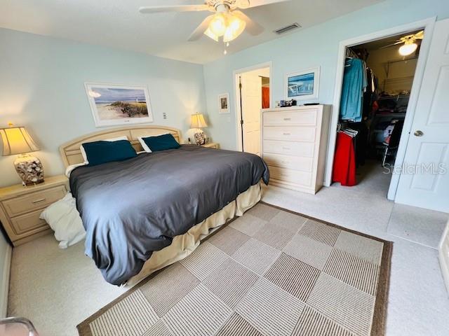 bedroom featuring ceiling fan, a closet, and a spacious closet