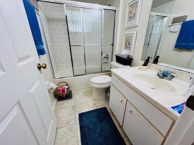 full bathroom with shower / bath combination with glass door, vanity, tile patterned floors, and toilet