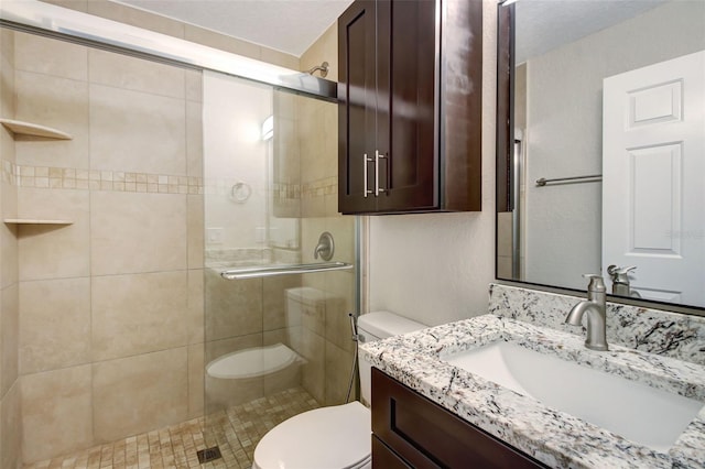 bathroom with walk in shower, vanity, and toilet