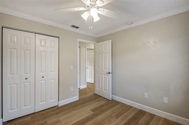 unfurnished bedroom featuring light hardwood / wood-style floors, ceiling fan, a closet, and crown molding