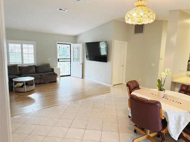 living room featuring a textured ceiling, vaulted ceiling, and light wood-type flooring