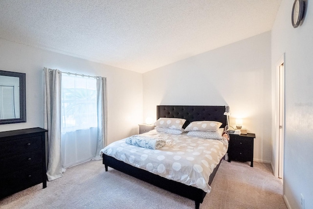 carpeted bedroom with a textured ceiling and lofted ceiling