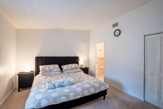 bedroom with a closet, light colored carpet, and a textured ceiling