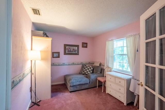 living area with carpet floors and a textured ceiling