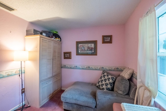 sitting room featuring light carpet and a textured ceiling