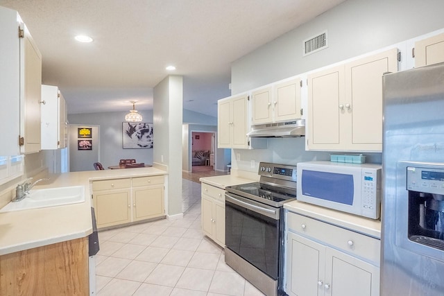 kitchen featuring light tile patterned flooring, appliances with stainless steel finishes, vaulted ceiling, and sink