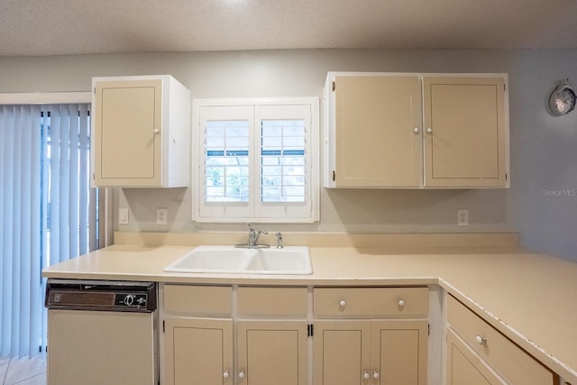 kitchen featuring a textured ceiling, dishwashing machine, and sink