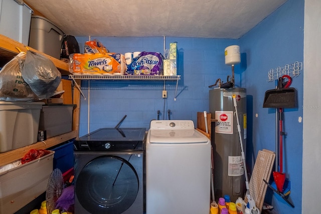 clothes washing area featuring washer and clothes dryer and water heater