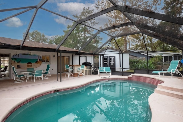 view of pool with glass enclosure, a patio area, and a shed