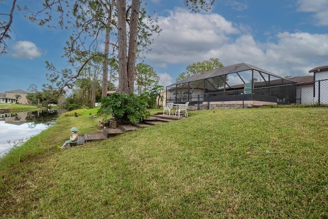 view of yard with a water view and glass enclosure