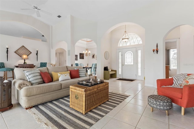 34 Clermont Ct, Palm Coast, FL 32137 - living room featuring arched walkways, light tile patterned floors, high vaulted ceiling, a chandelier, and ceiling fan