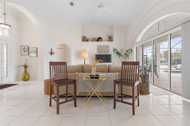 sitting room featuring high vaulted ceiling and light tile patterned flooring