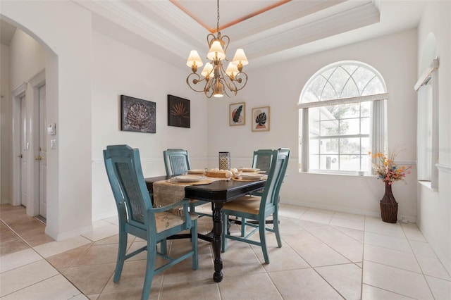 dining space with a raised ceiling, light tile patterned floors, crown molding, and a chandelier