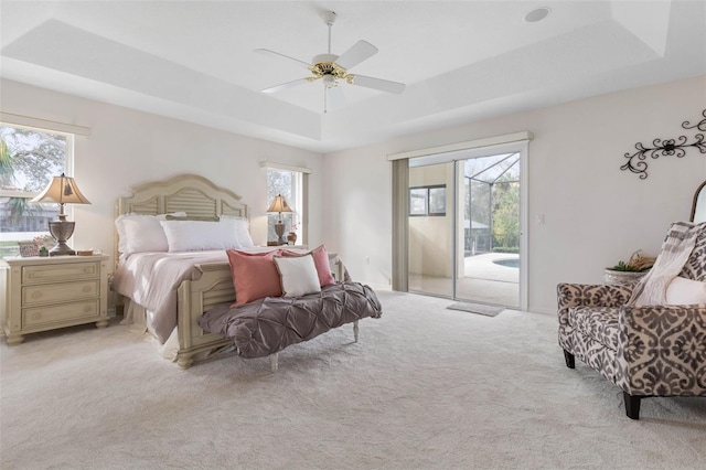 34 Clermont Ct, Palm Coast, FL 32137 - bedroom featuring a tray ceiling, access to exterior, light carpet, and a ceiling fan