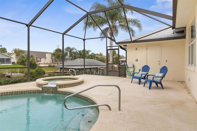 view of pool with an in ground hot tub, pool water feature, glass enclosure, and a patio area