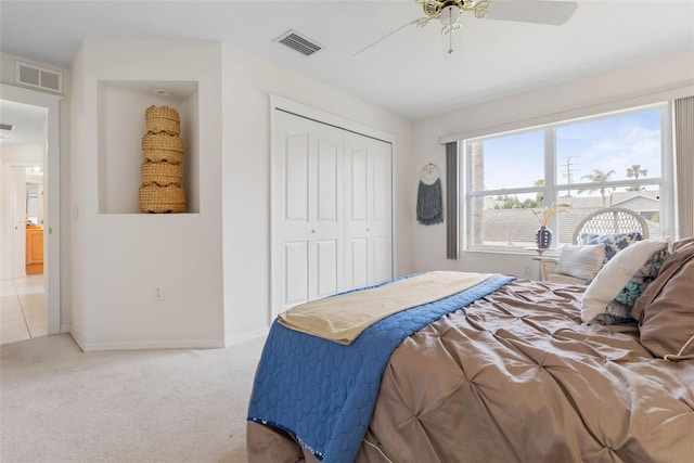 bedroom with ceiling fan, light colored carpet, and a closet