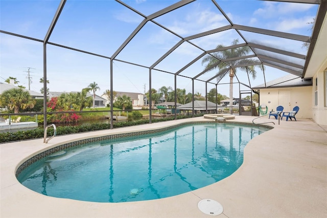 view of swimming pool featuring glass enclosure, an in ground hot tub, and a patio