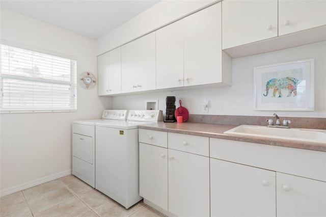 laundry room featuring cabinets, light tile patterned floors, sink, and washing machine and clothes dryer