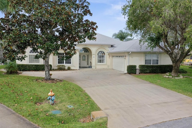 view of front of home with a front yard and a garage