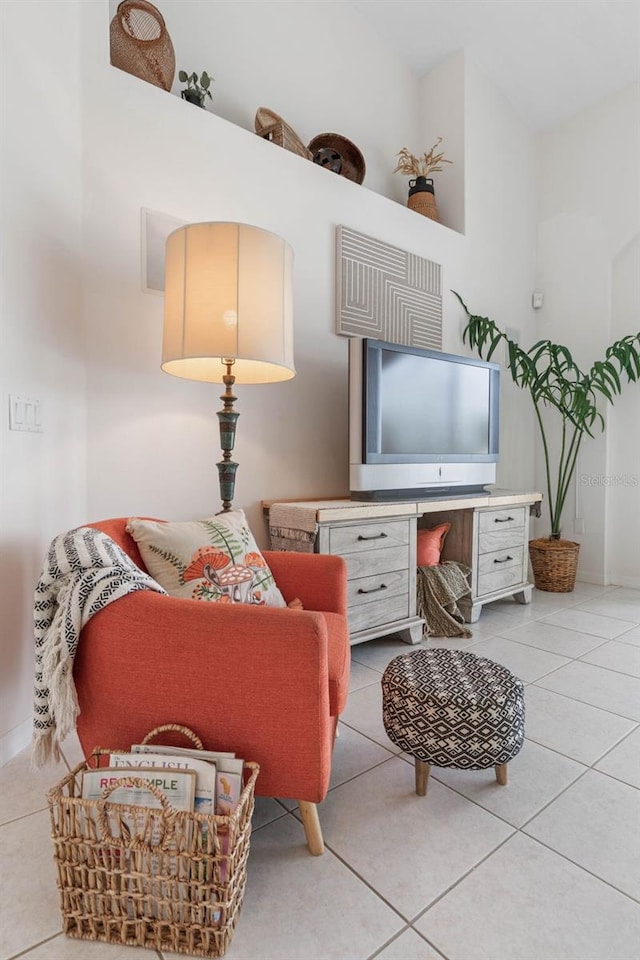 sitting room featuring light tile patterned flooring and a high ceiling