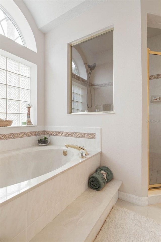 bathroom with separate shower and tub and tile patterned flooring