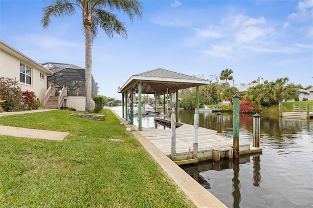 view of dock with a yard, a water view, and a lanai