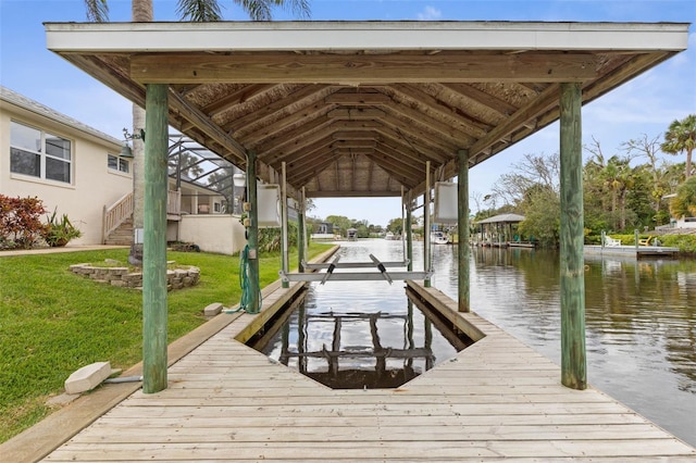 view of dock with a yard and a water view