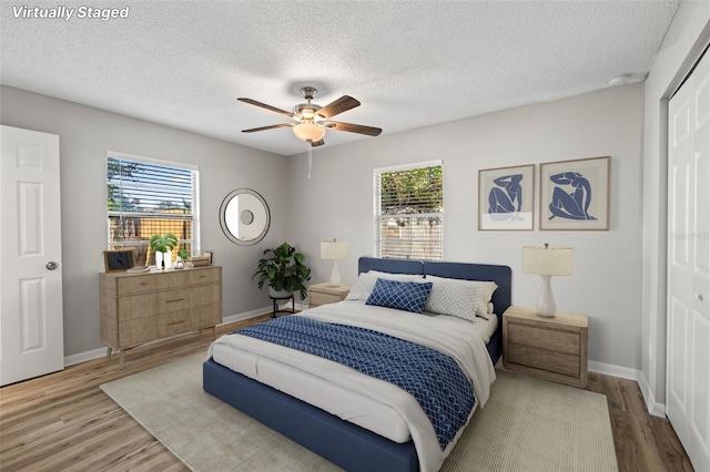 bedroom with a closet, multiple windows, and wood-type flooring