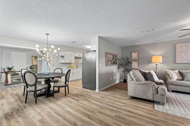 living room with light hardwood / wood-style floors, a textured ceiling, and sink