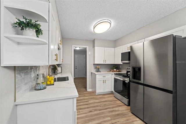 kitchen with white cabinetry, decorative backsplash, stainless steel appliances, and sink