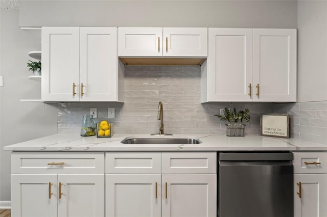 kitchen with dishwasher, tasteful backsplash, sink, and white cabinets