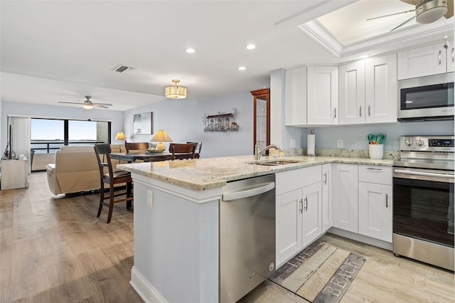 kitchen featuring white cabinetry, sink, stainless steel appliances, and light wood-type flooring