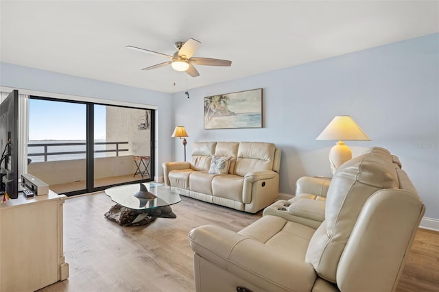 living room with ceiling fan and light hardwood / wood-style flooring