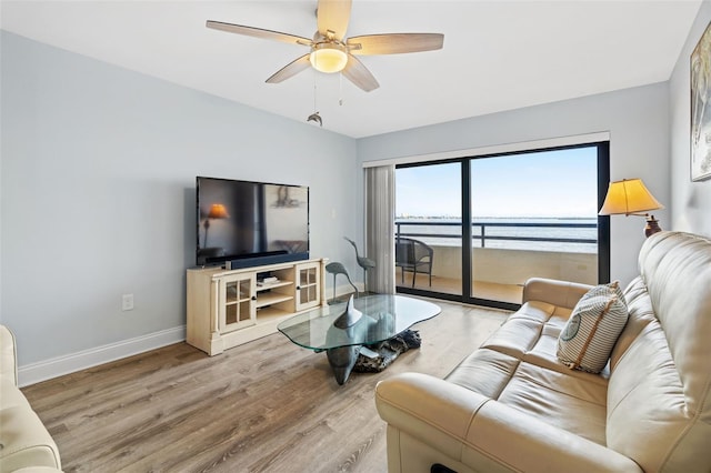 living room featuring light hardwood / wood-style flooring and ceiling fan